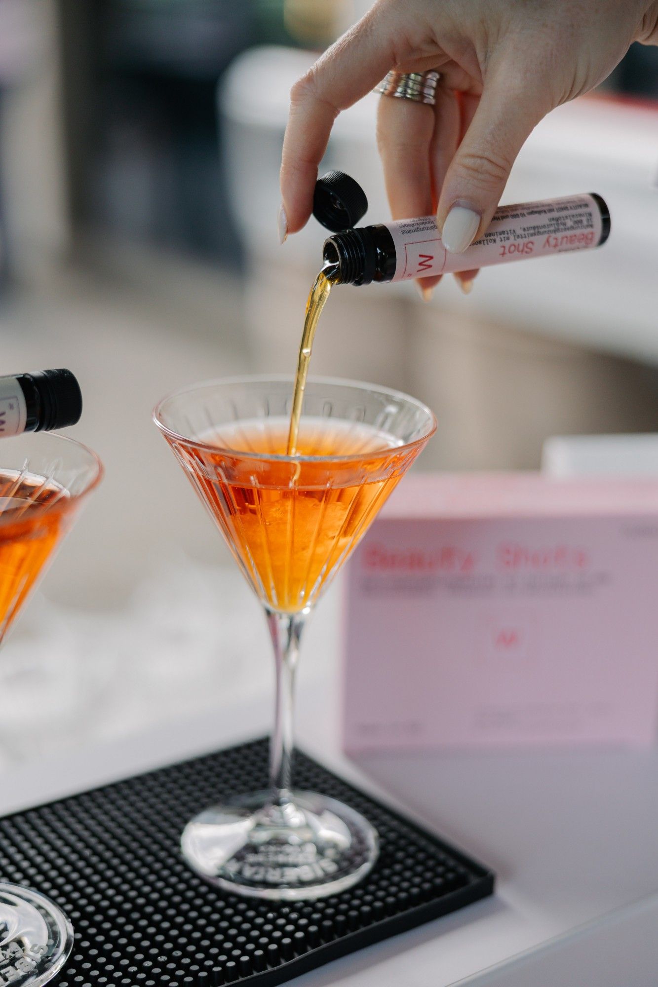 Ein Beauty Shot wird in ein Cocktailglas gegossen.