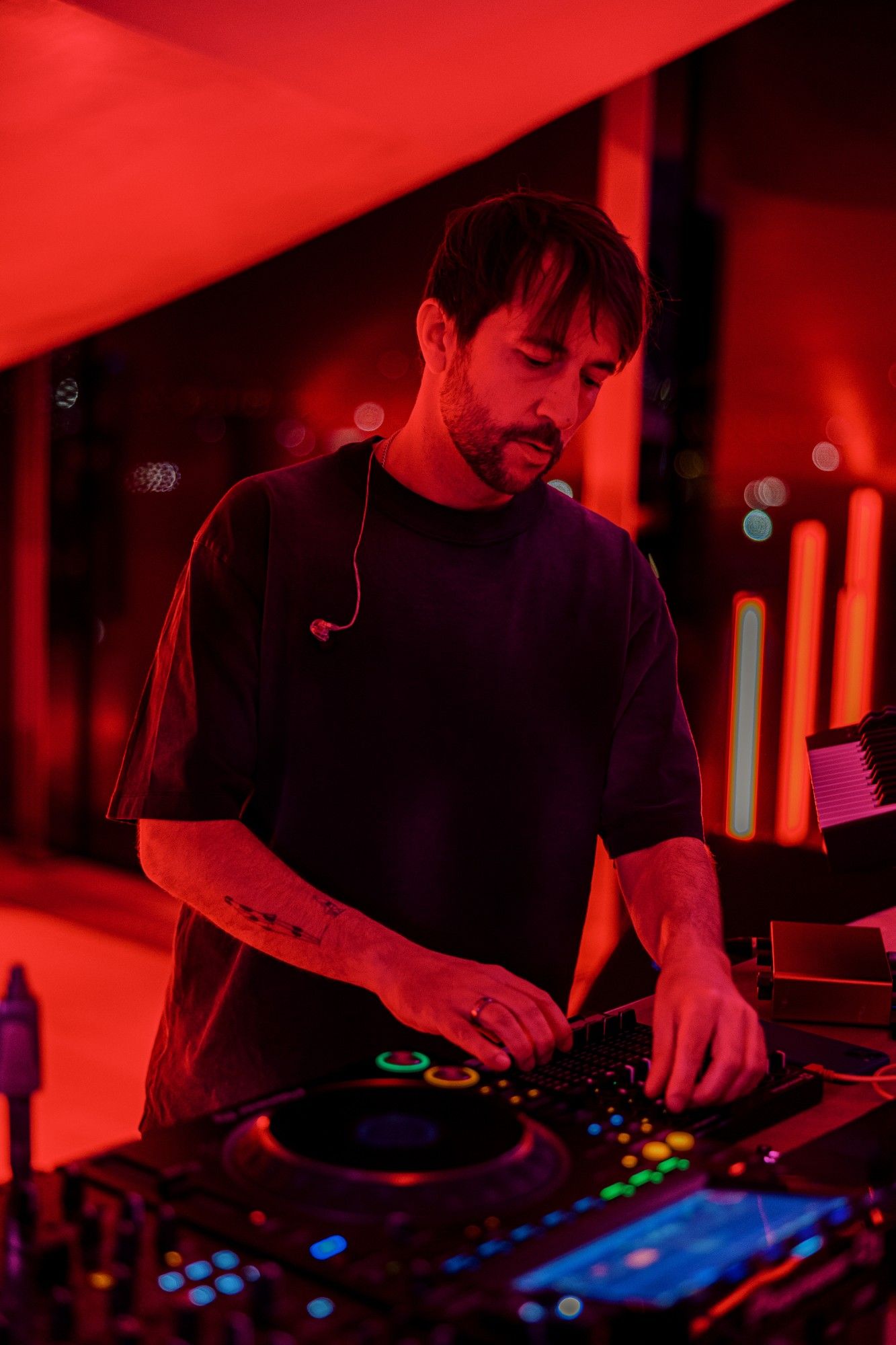 DJ am Pult im roten Licht.