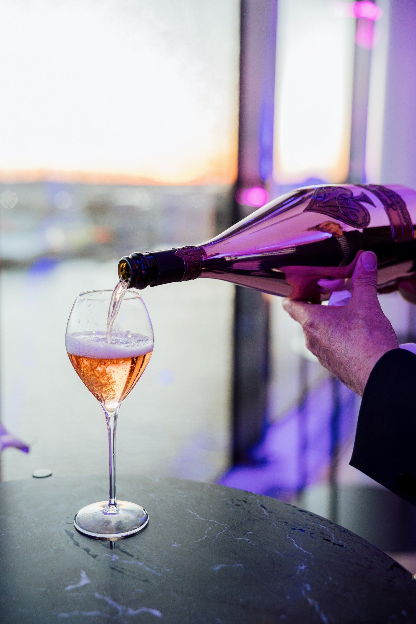 Rosé-Champagner wird in ein Glas eingeschenkt.