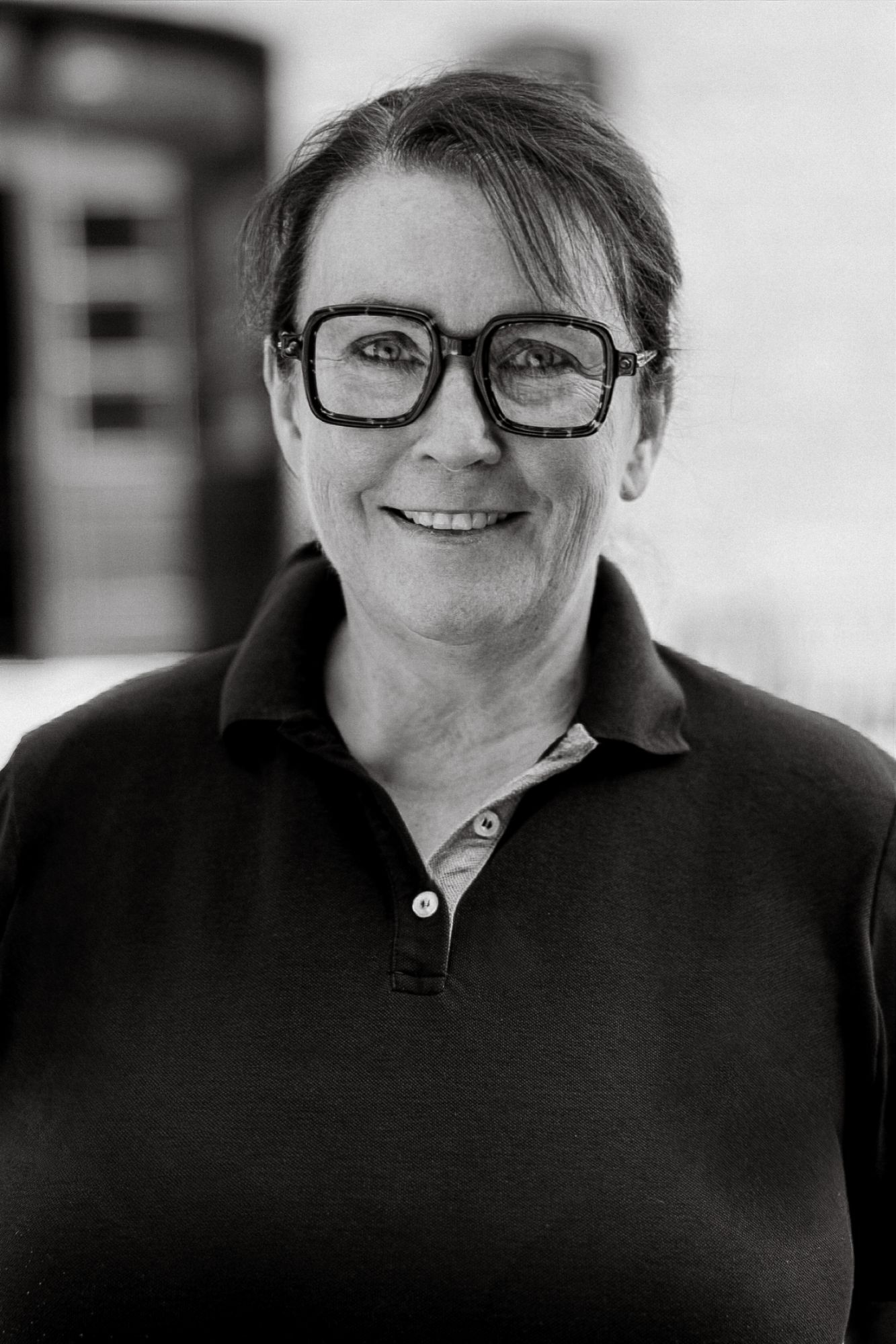 Schwarzweiß-Portrait einer Tierärztin mit Brille.
