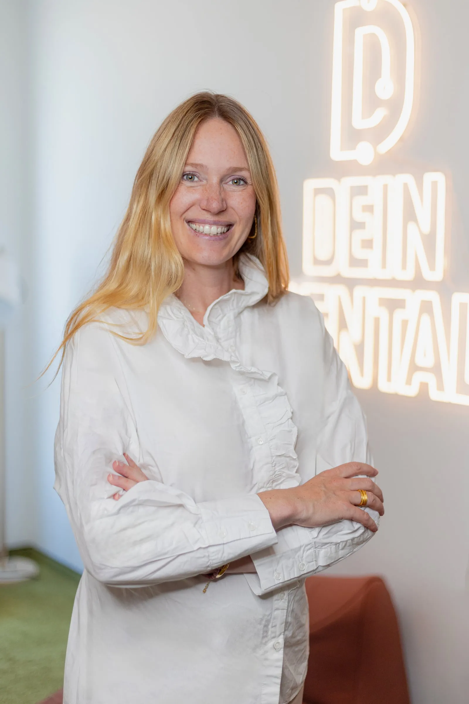 Portrait einer Führungskraft vor dem beleuchteten Dein-Dental-Logo.