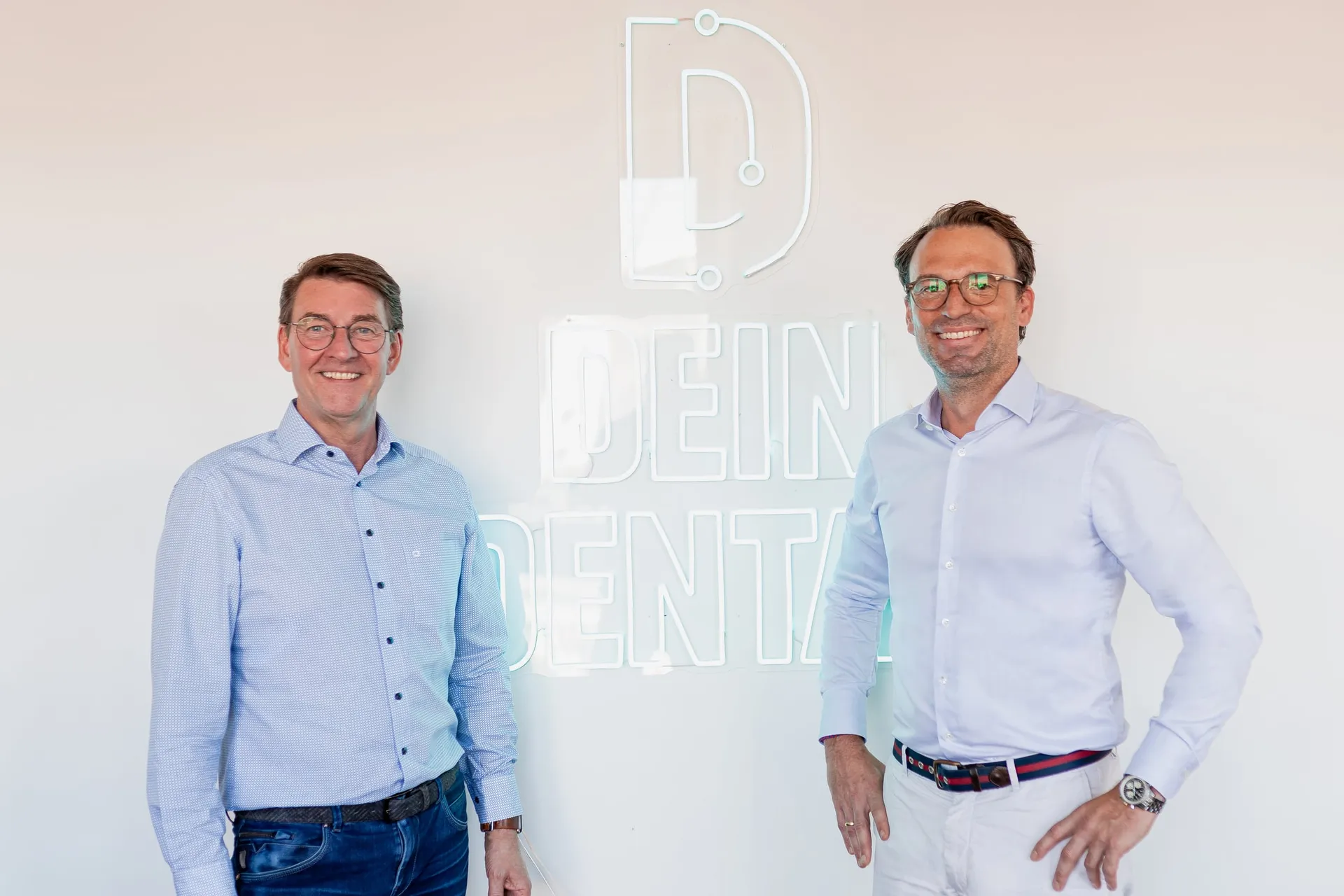 Zwei Geschäftsführer vor der Dein-Dental-Wand.
