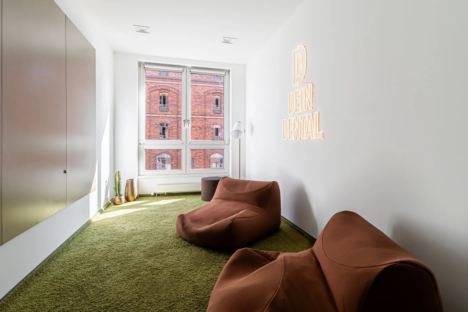 Lounge mit Sitzsäcken und Leuchtschrift.