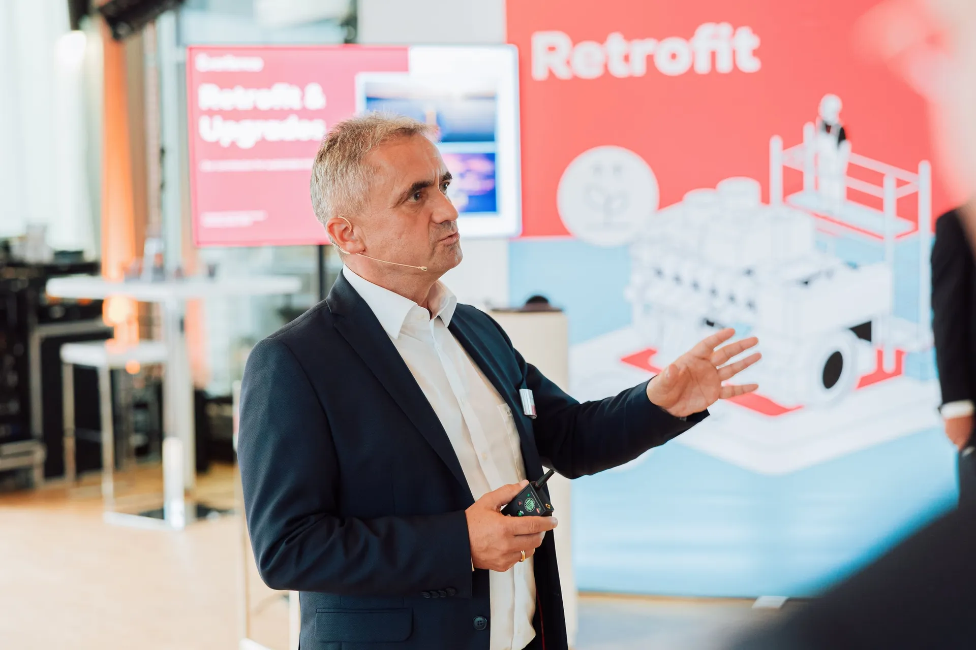 Gesprächspartner erklärt vor dem Retrofit-Display.