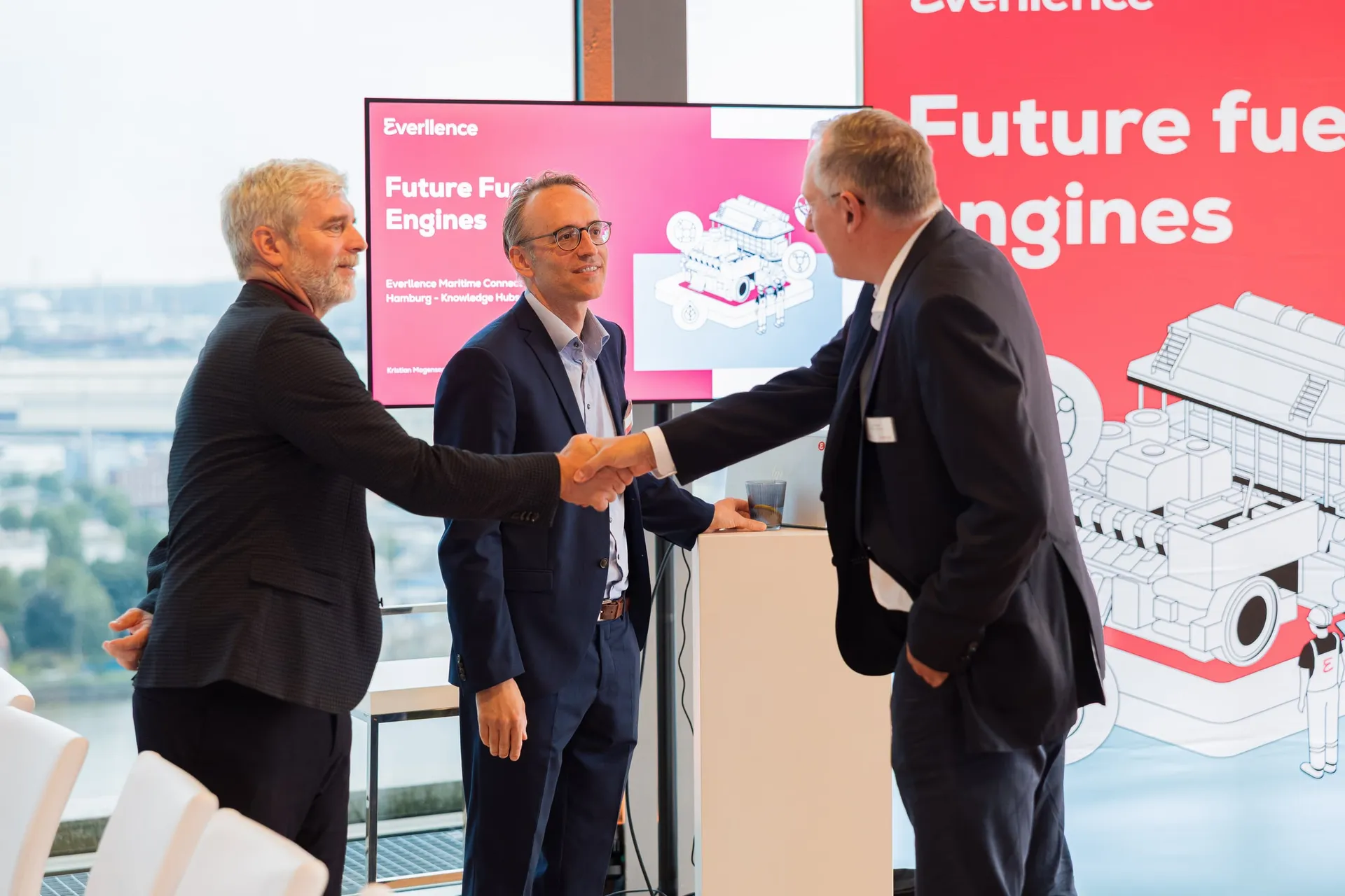 Handschlag vor dem Future-Fuel-Engines-Display.