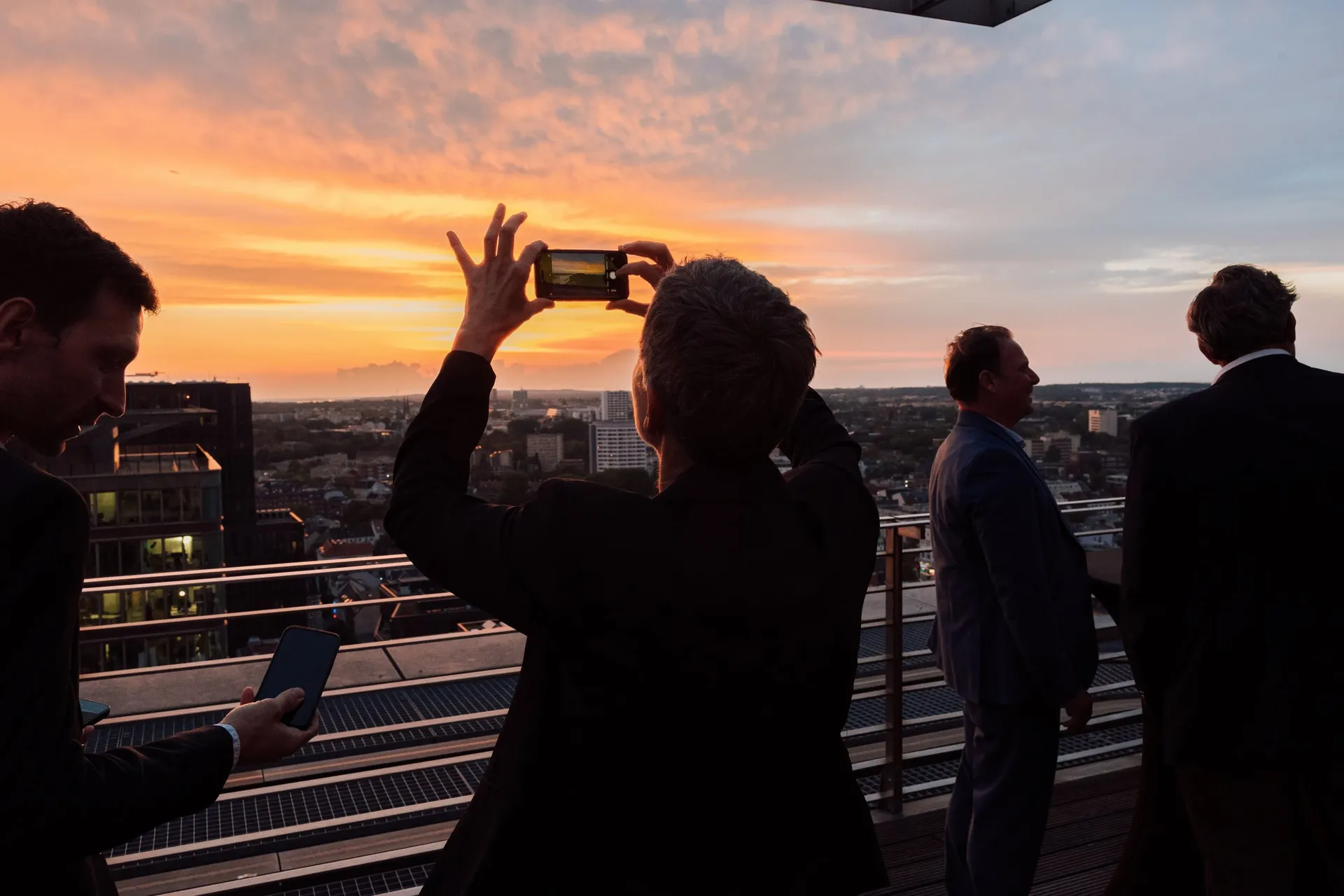 Silhouetten vor dem Sonnenuntergang über dem Hafen.