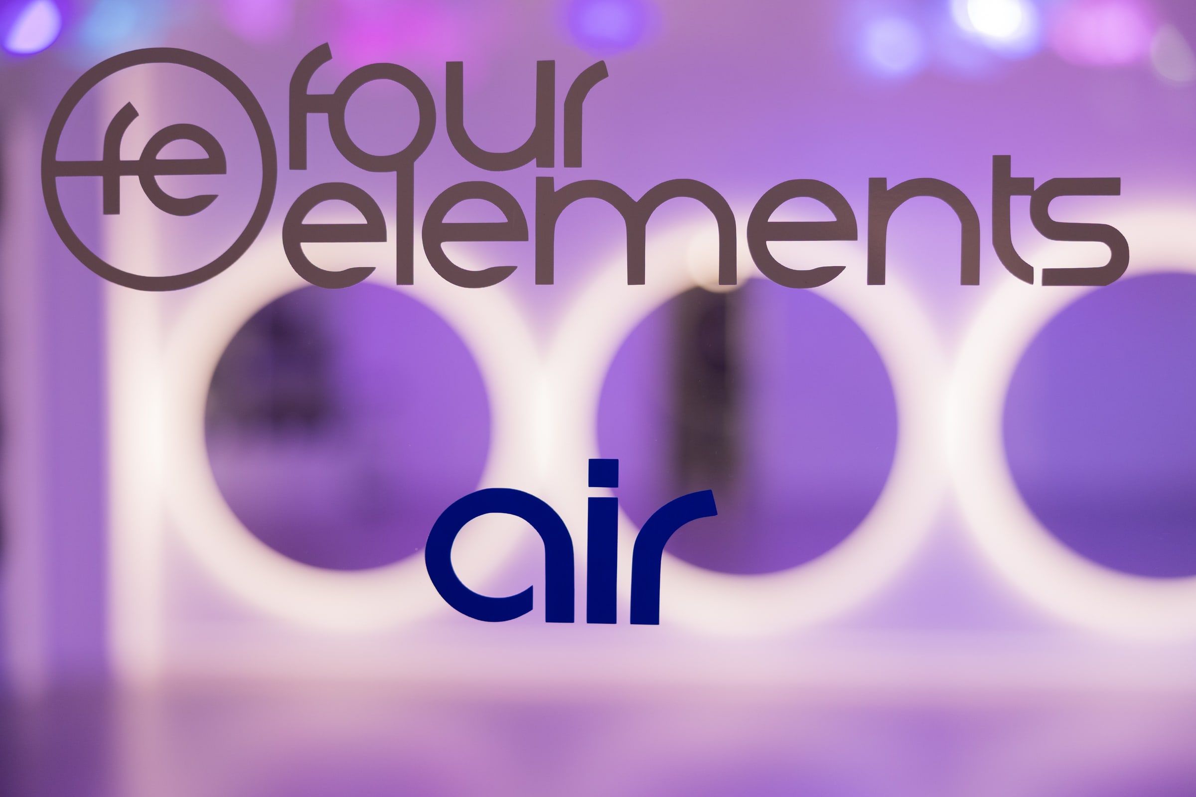 Schriftzug Four Elements air auf Glas, dahinter beleuchtete Spiegel.