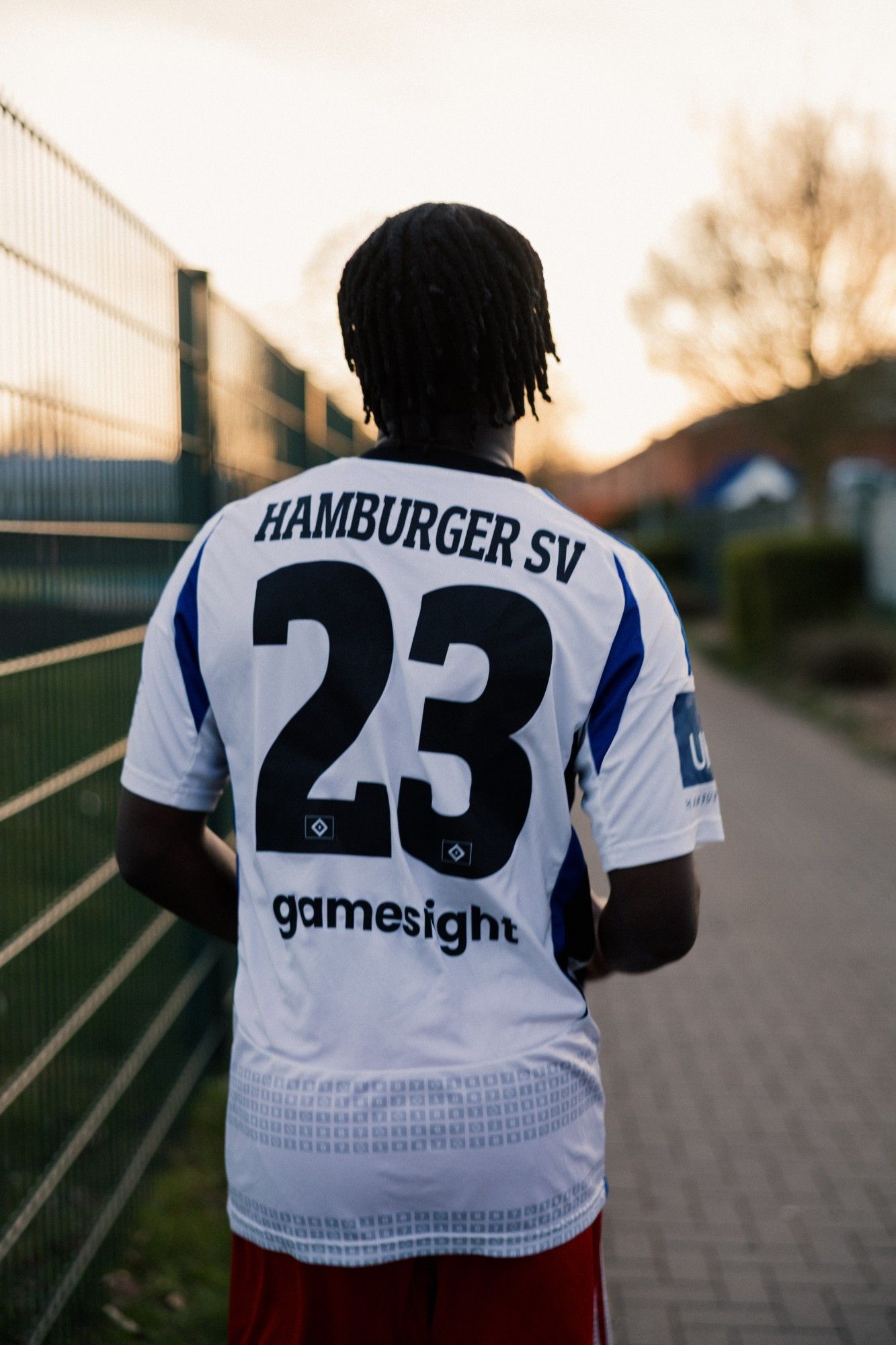 Spieler von hinten mit HSV-Trikot und der Nummer 23 im Gegenlicht.