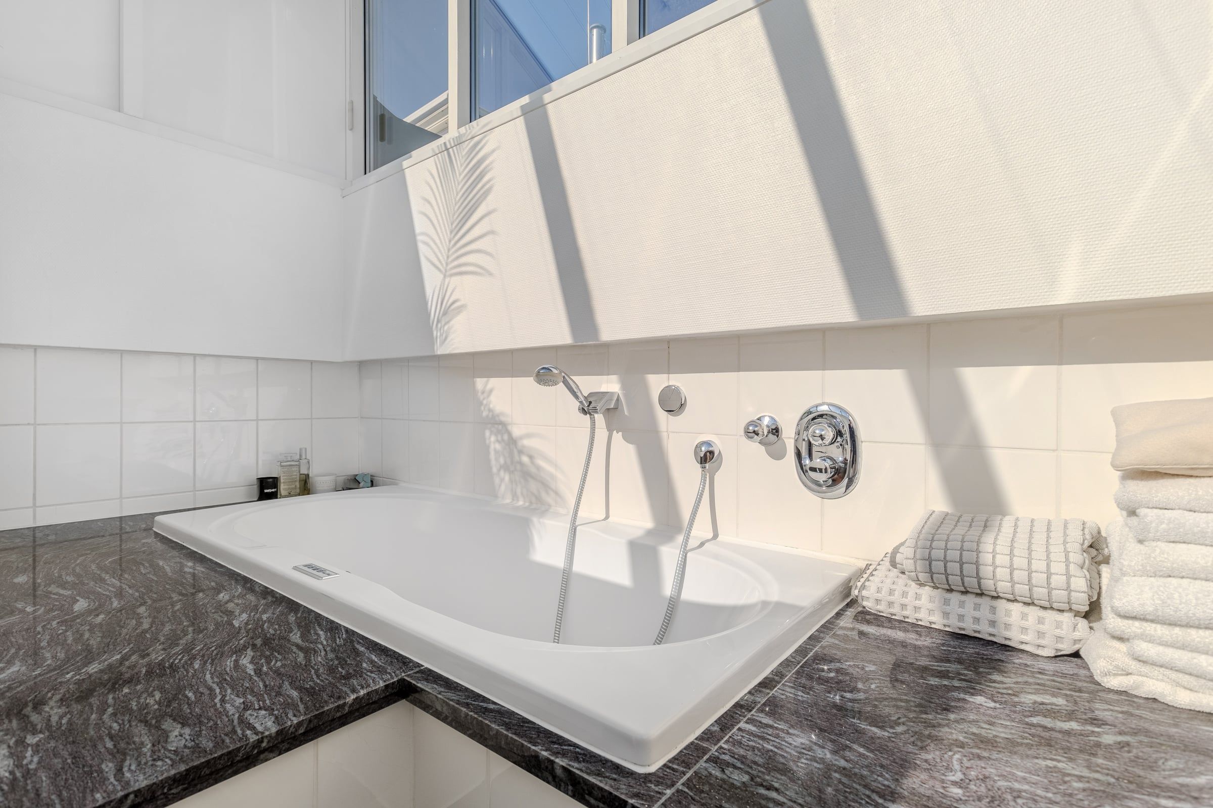 Badewanne unter einem Dachfenster.