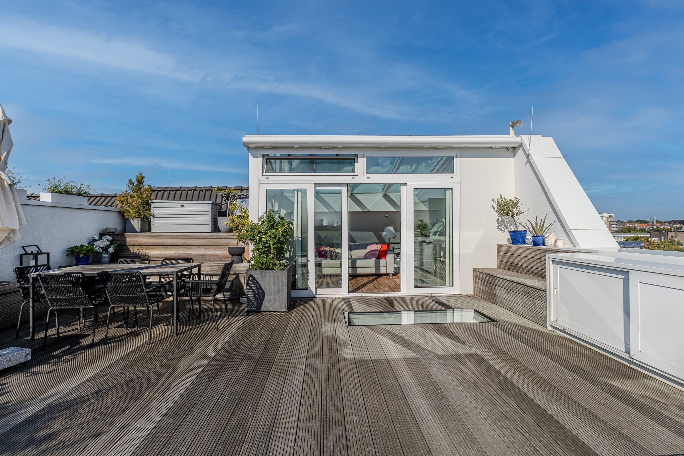 Dachterrasse mit Holzboden und verglastem Aufgang.