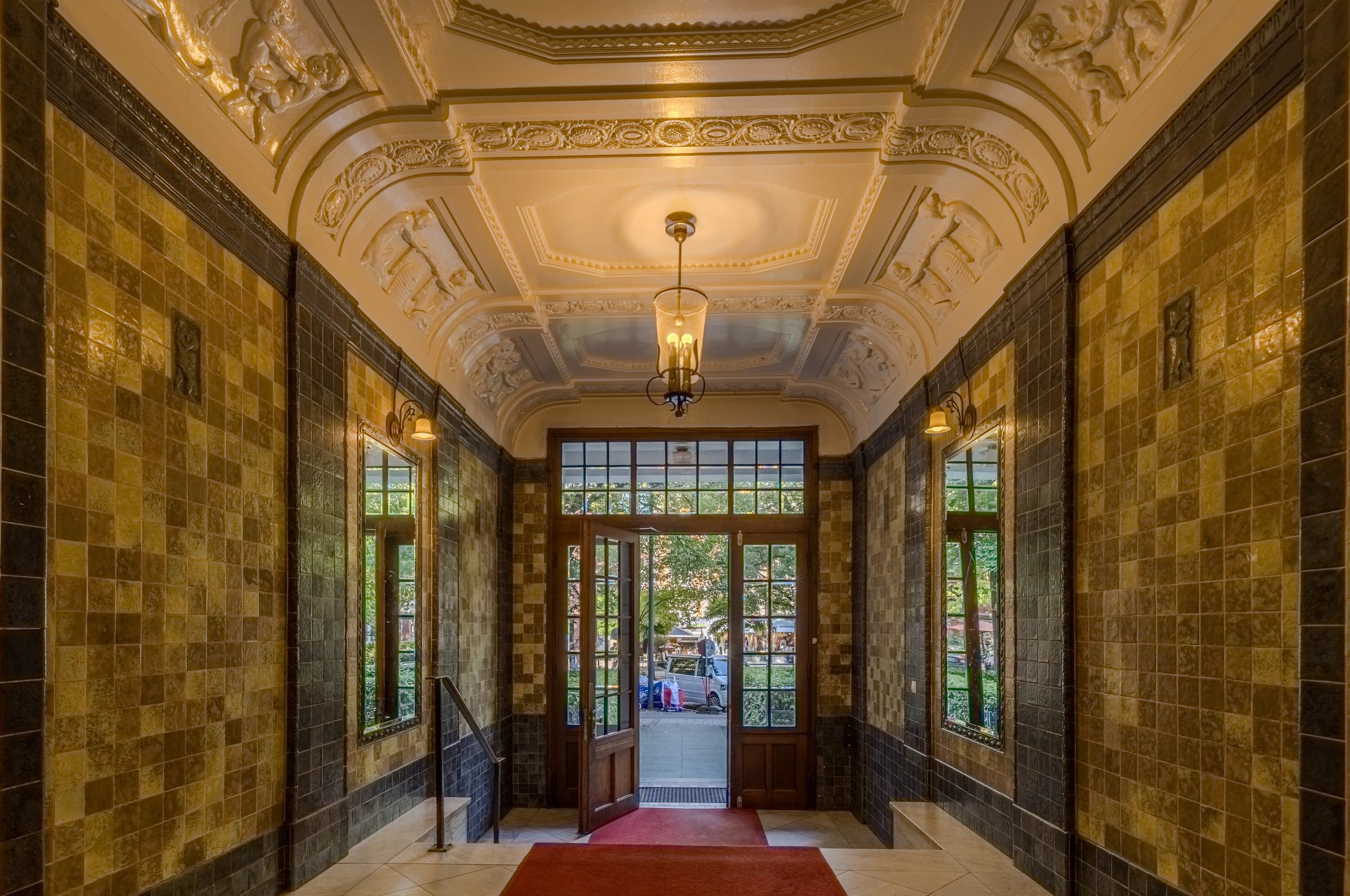 Historisches Foyer mit Fliesen und Stuckdecke.