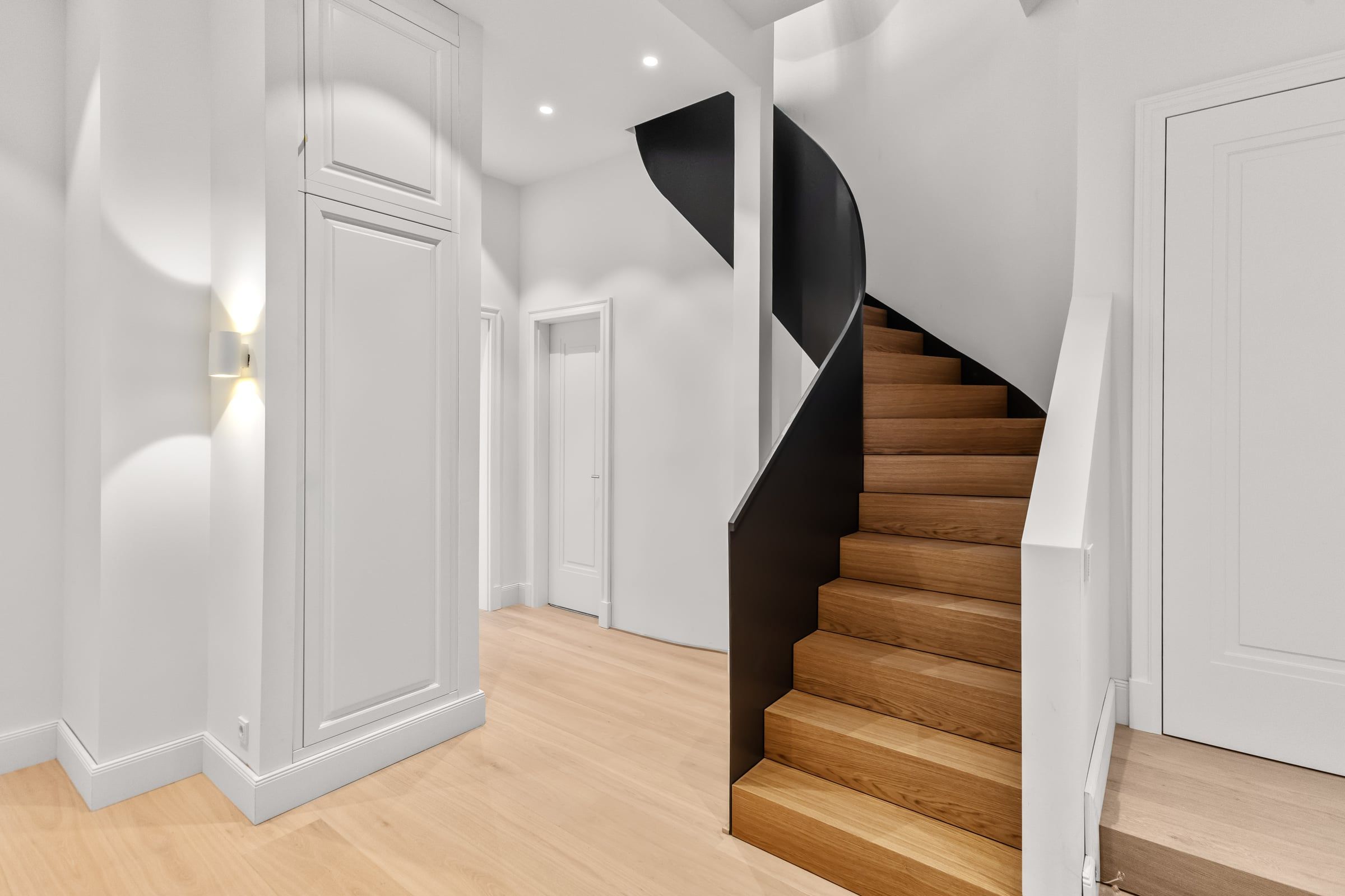Schwarze Wendeltreppe mit Holzstufen.