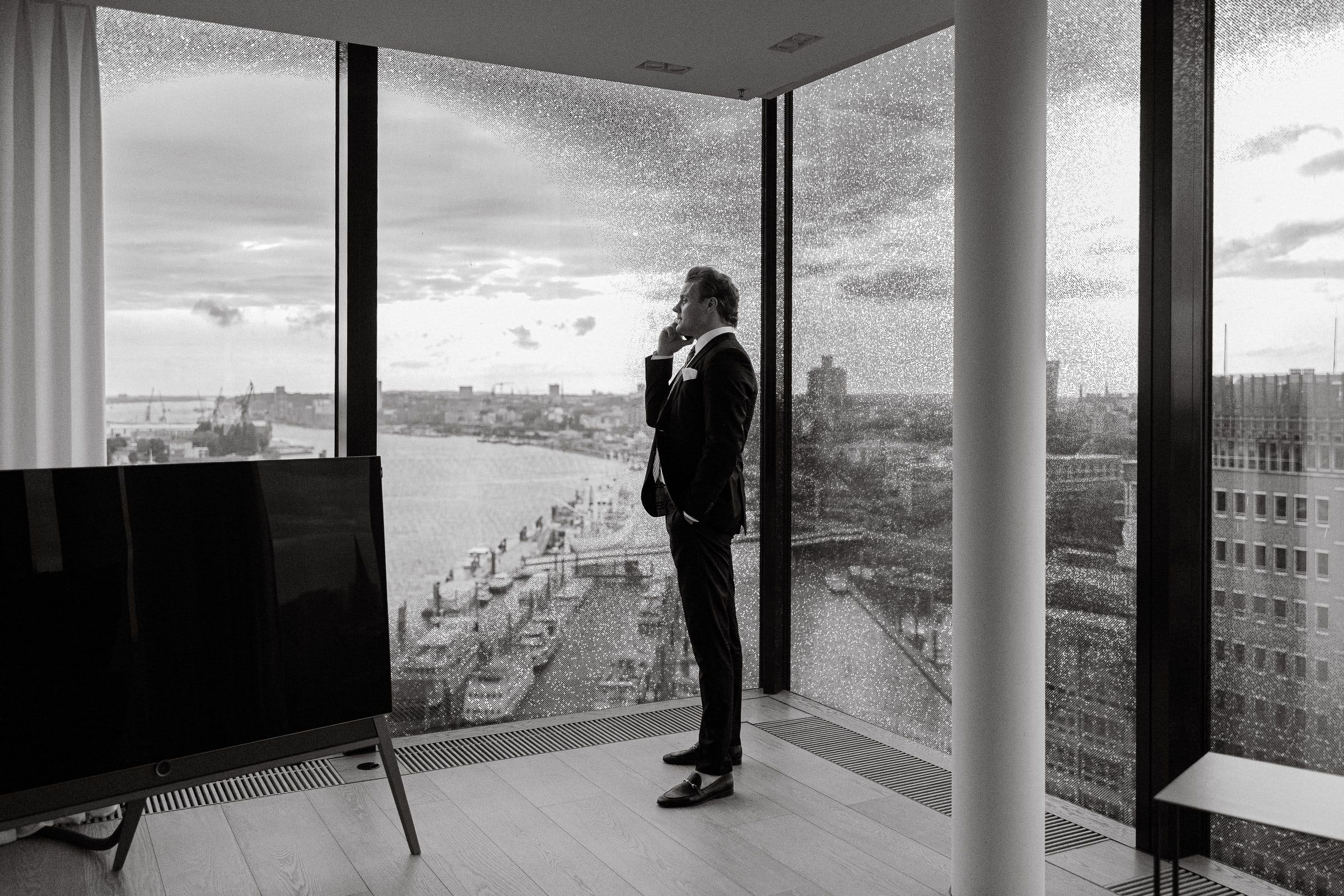 Schwarzweiß: Björn Meins am Fenster mit Hafenblick.