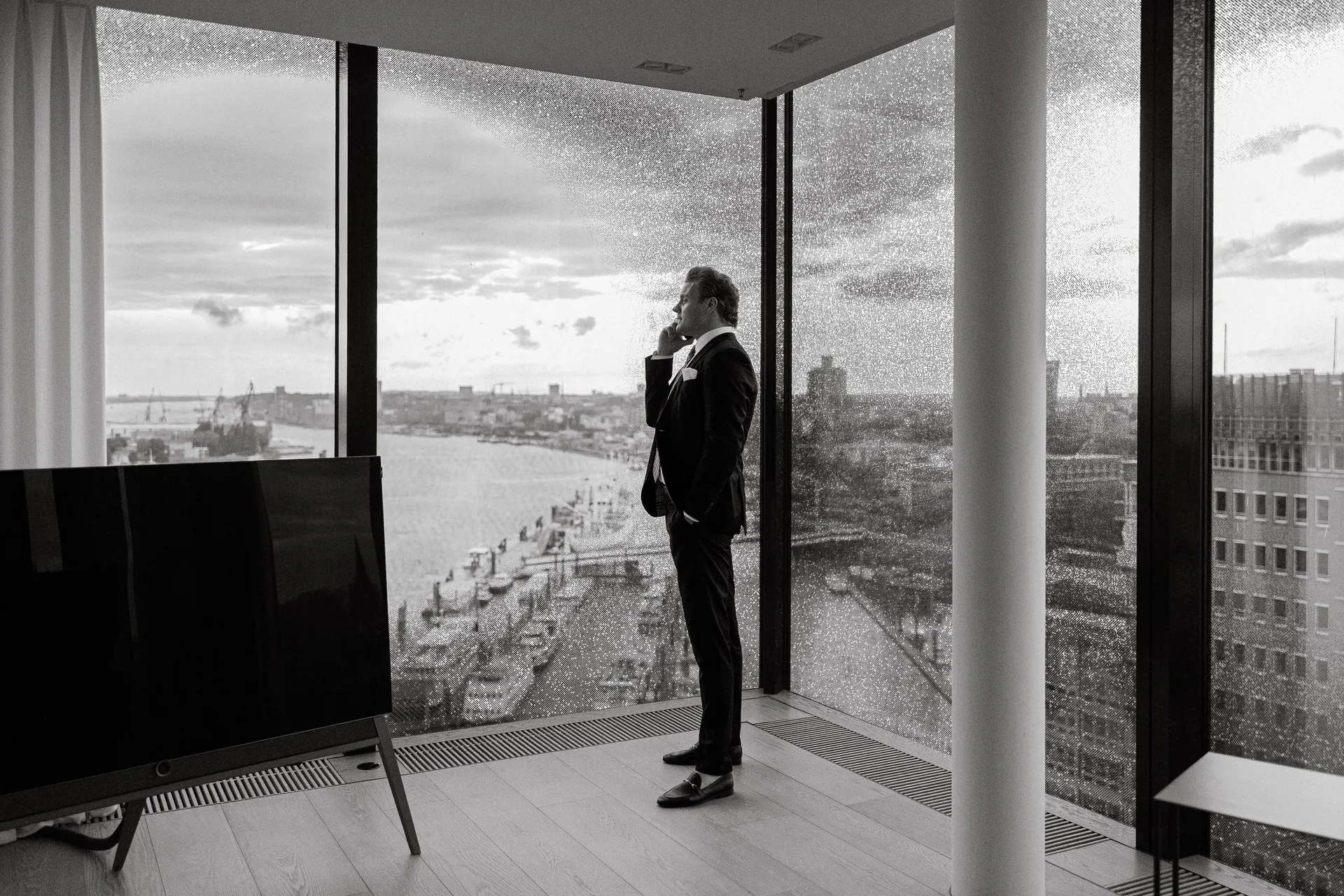 Schwarzweiß: Björn Meins am Fenster mit Hafenblick.