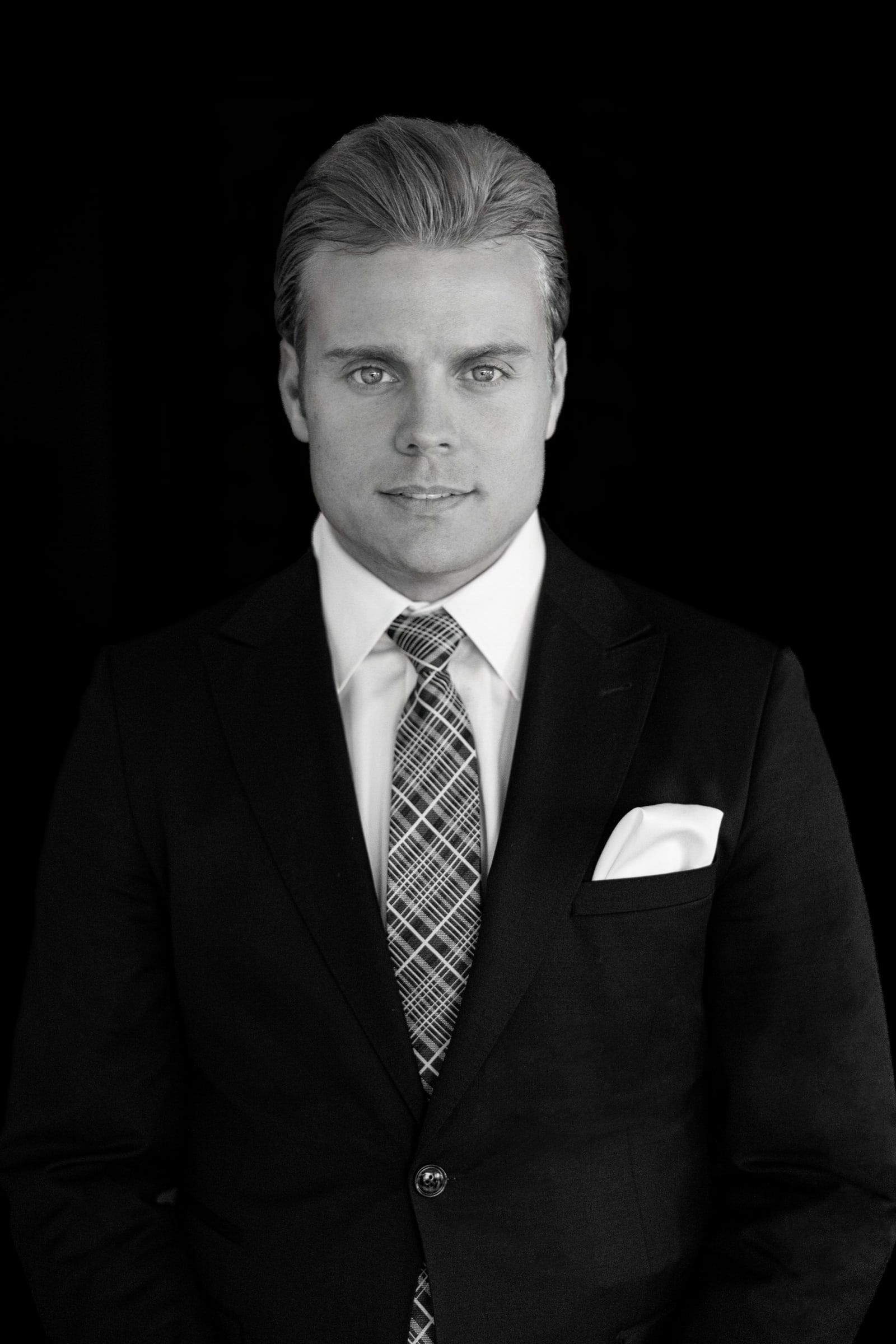 Schwarzweiß-Portrait von Björn Meins vor dunklem Hintergrund.
