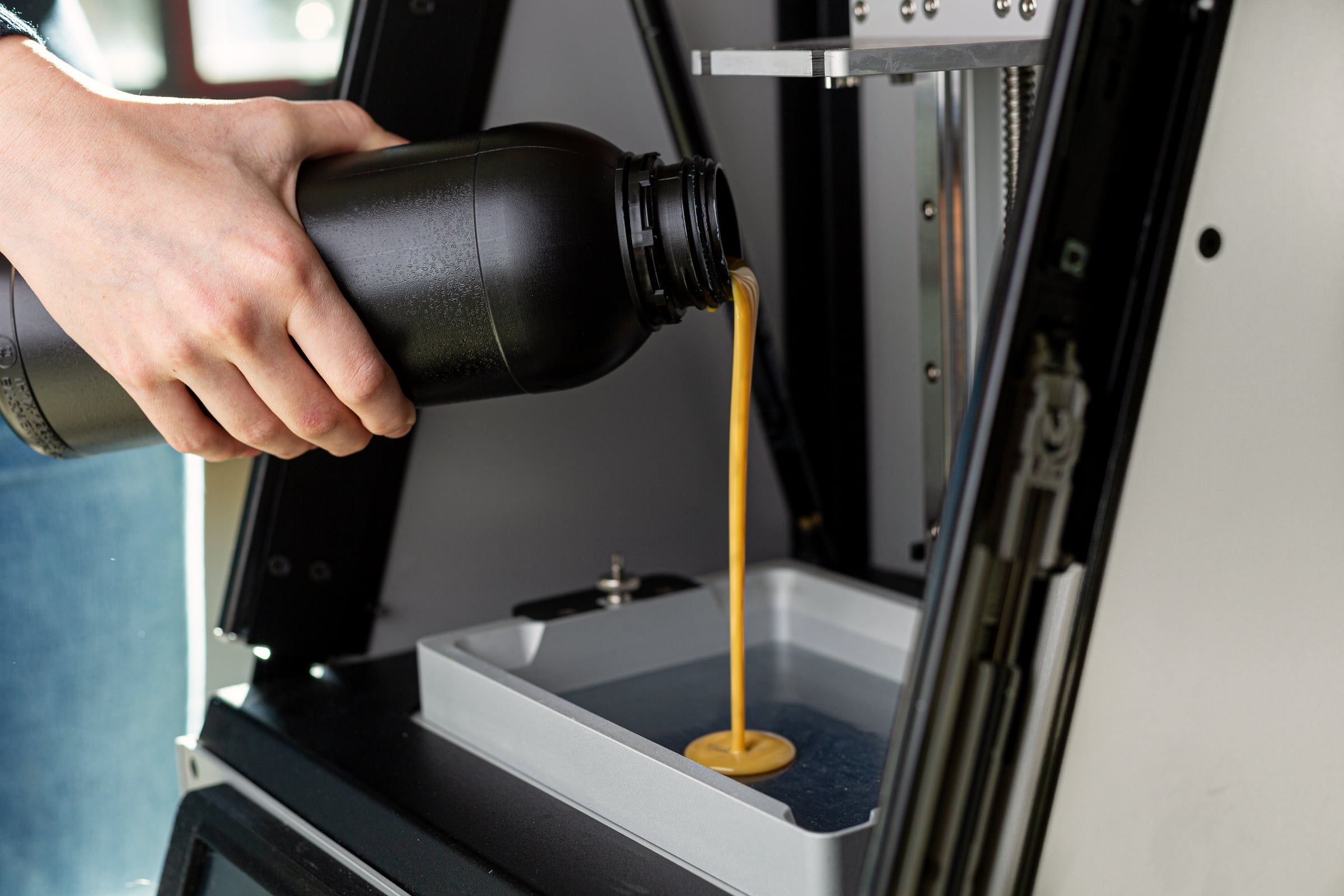 Harz wird in den 3D-Drucker gegossen.
