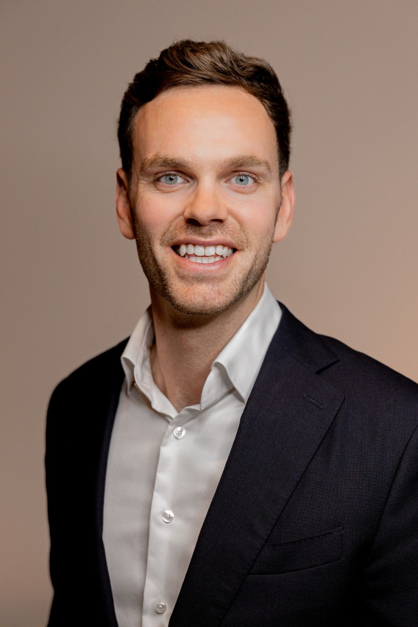 Businessportrait eines Mitarbeiters in dunklem Sakko.